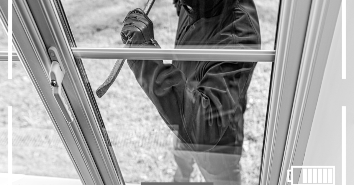 Burglar with crowbar at window. Security window film can help prevent this from happening.